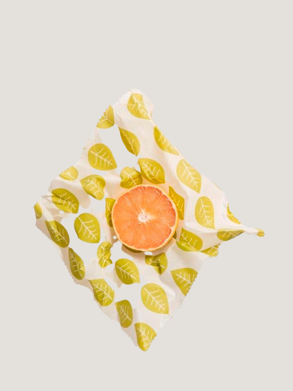 en halv appelsin i bivokspapir med motiv af blade